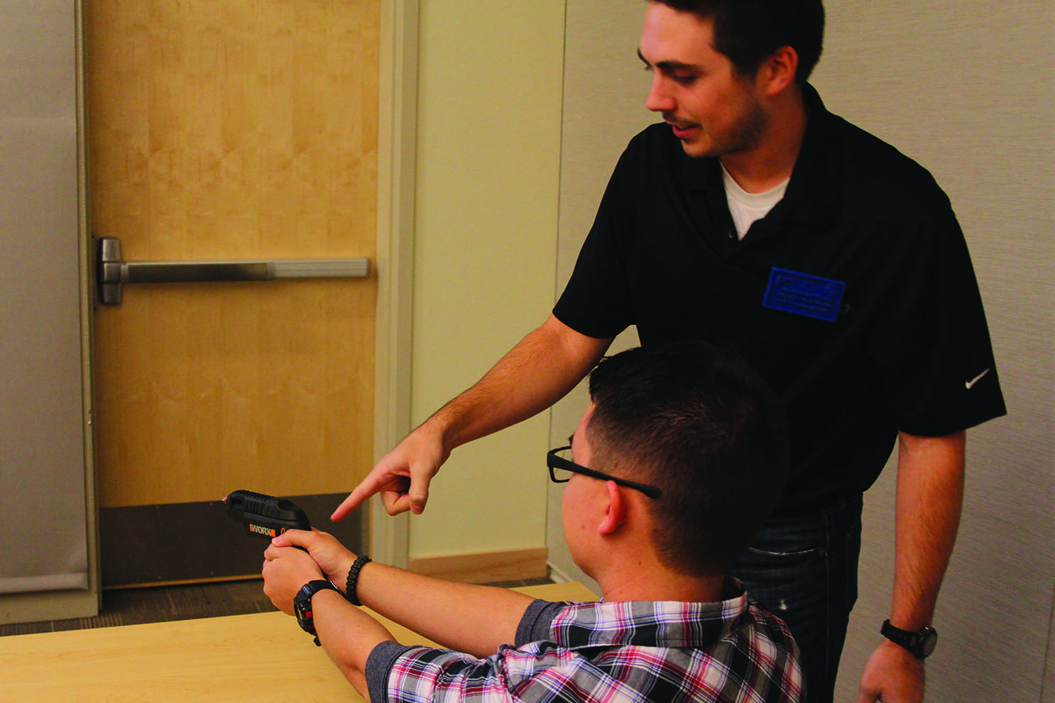 Andrew Fletcher, an NRA certified instructor who worked as an armored truck driver, demonstrates proper gun safety to Karl Schwingen, a sophomore Fish and Wildlife Biology major, Monday night during a concealed carry safety class. (Photo credit: Kevin Olson.)
